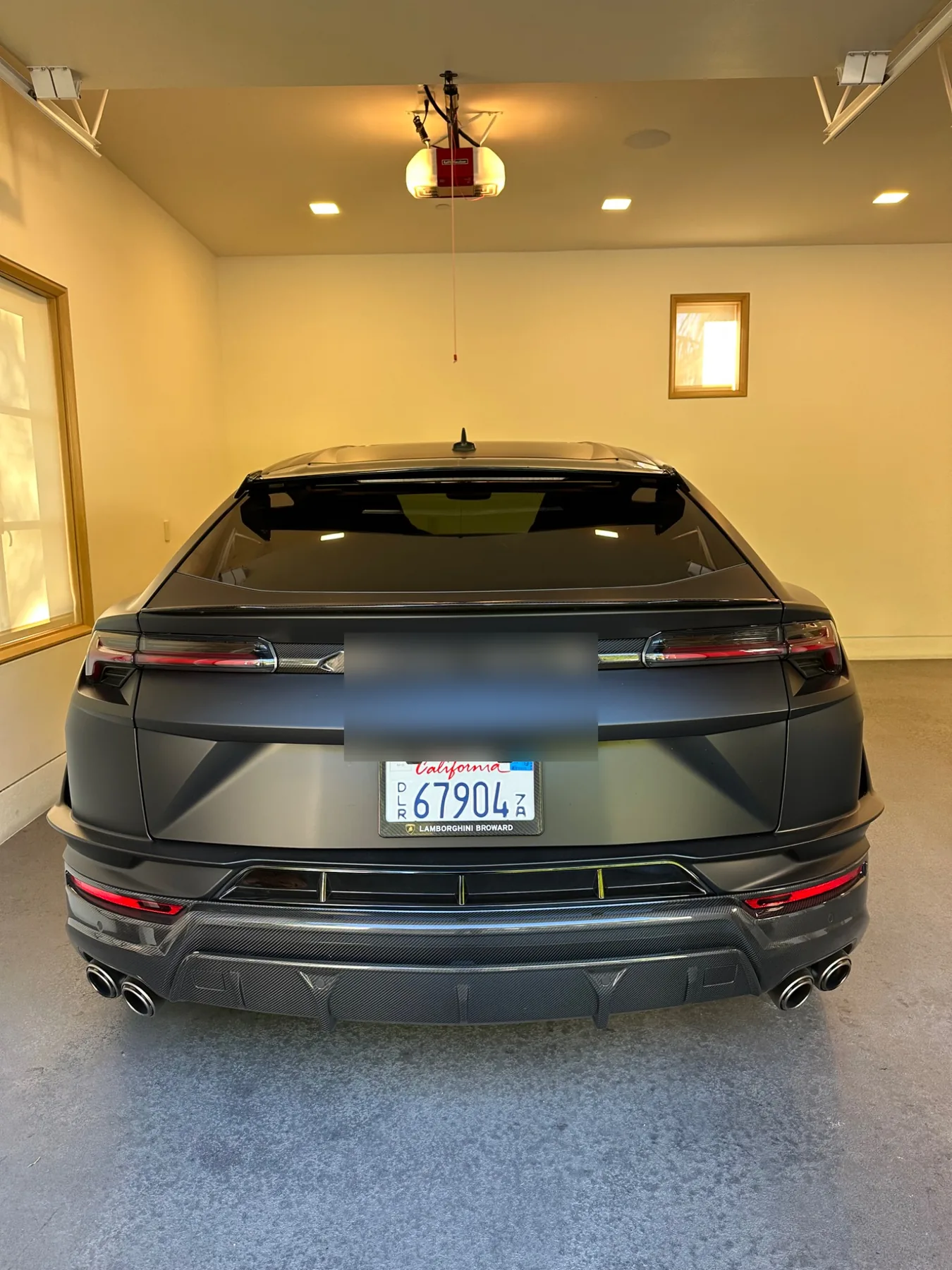 Rear view of a matte black Lamborghini with finished window tint