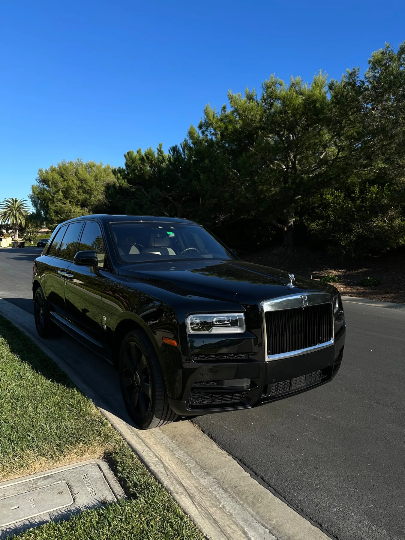 Black Rolls-Royce SUV with finished dark tint parked outside
